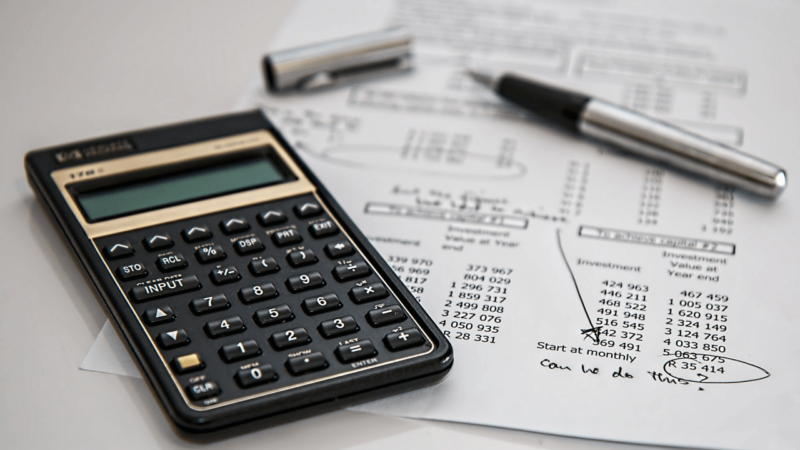 A calculator on top of a piece of paper with numbers.