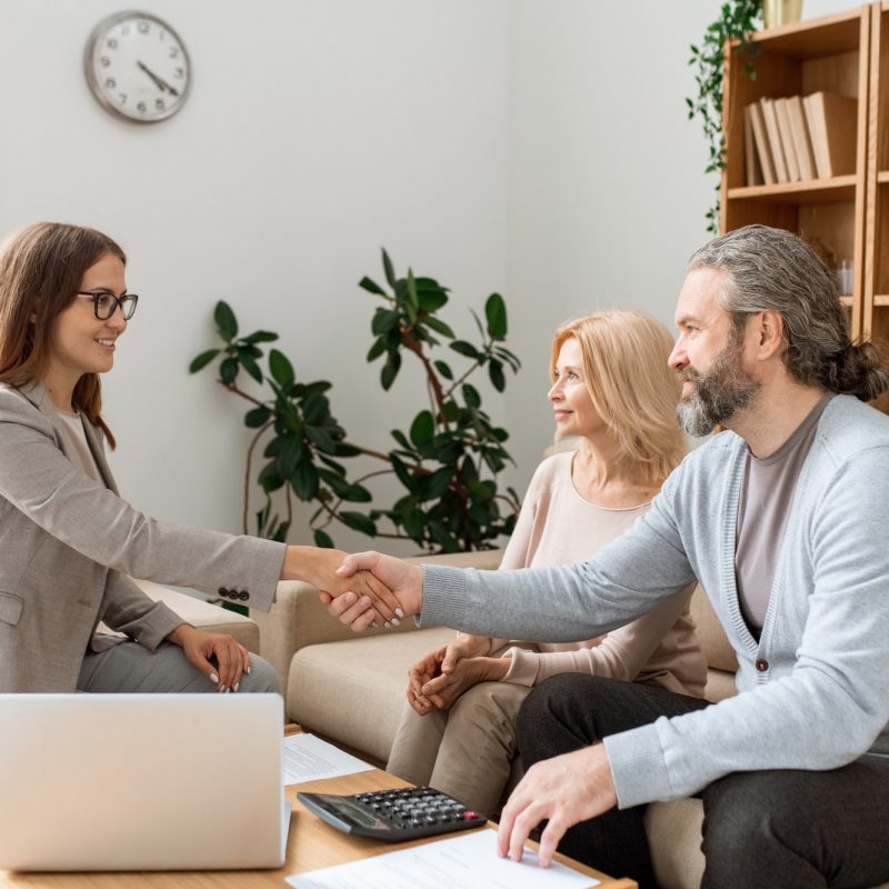 casual-bearded-man-shaking-hand-of-young-female-real-estate-agent-over-desk.jpg